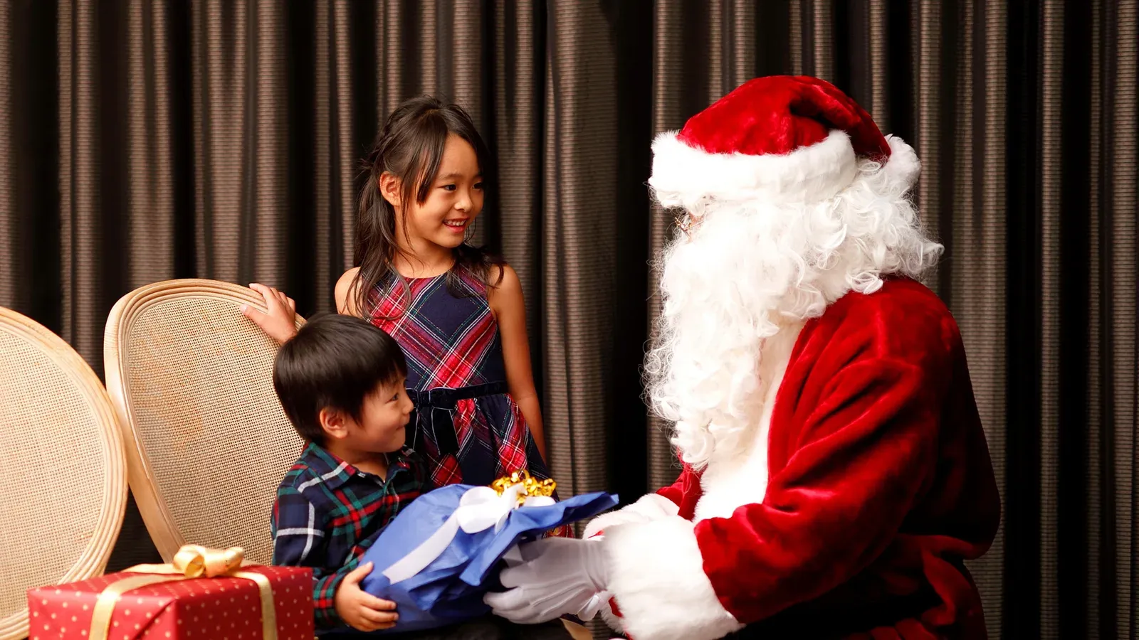 Santa handing a present to two children at a past Christmas family buffet at Hotel New Otani Tokyo
